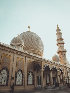 A serene morning view of injii mosque's golden dome shimmering under soft sunlight.