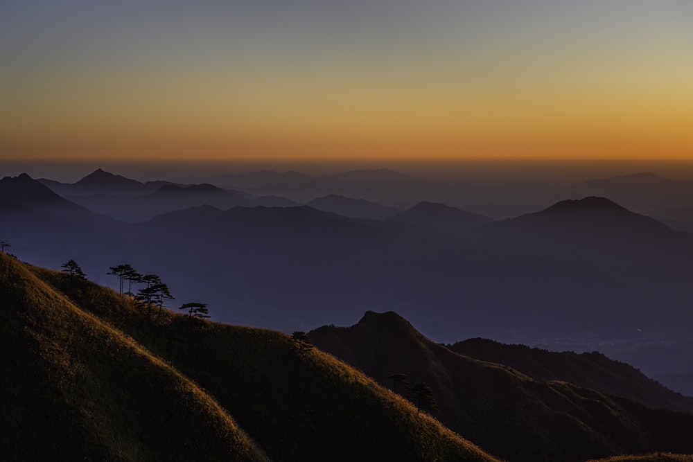 people on top of mountain during sunset