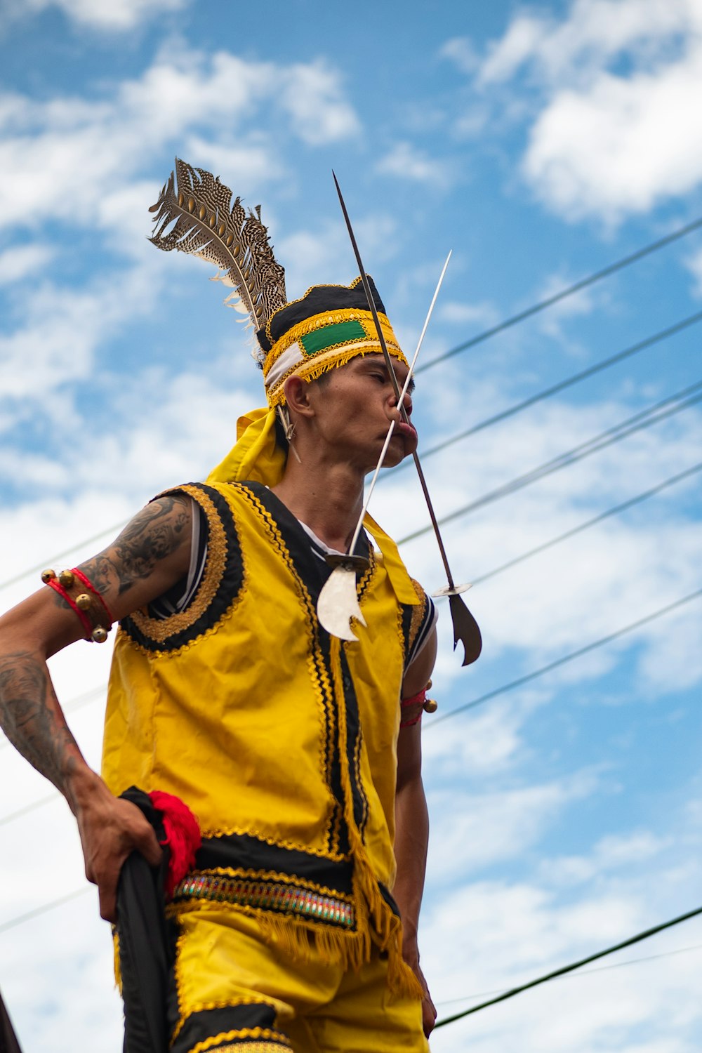 man in yellow and red jersey shirt holding brown rope during daytime