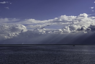 blue sea under blue sky and white clouds during daytime