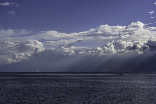 blue sea under blue sky and white clouds during daytime