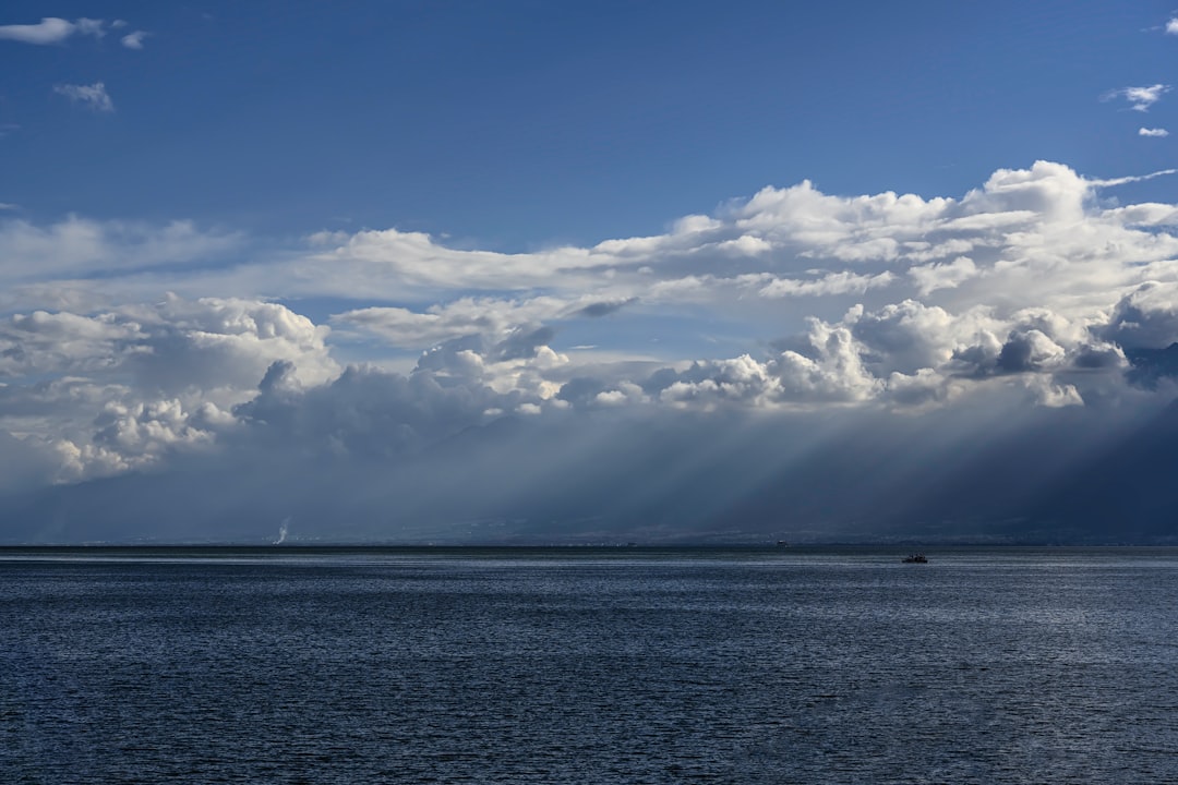 blue sea under blue sky and white clouds during daytime