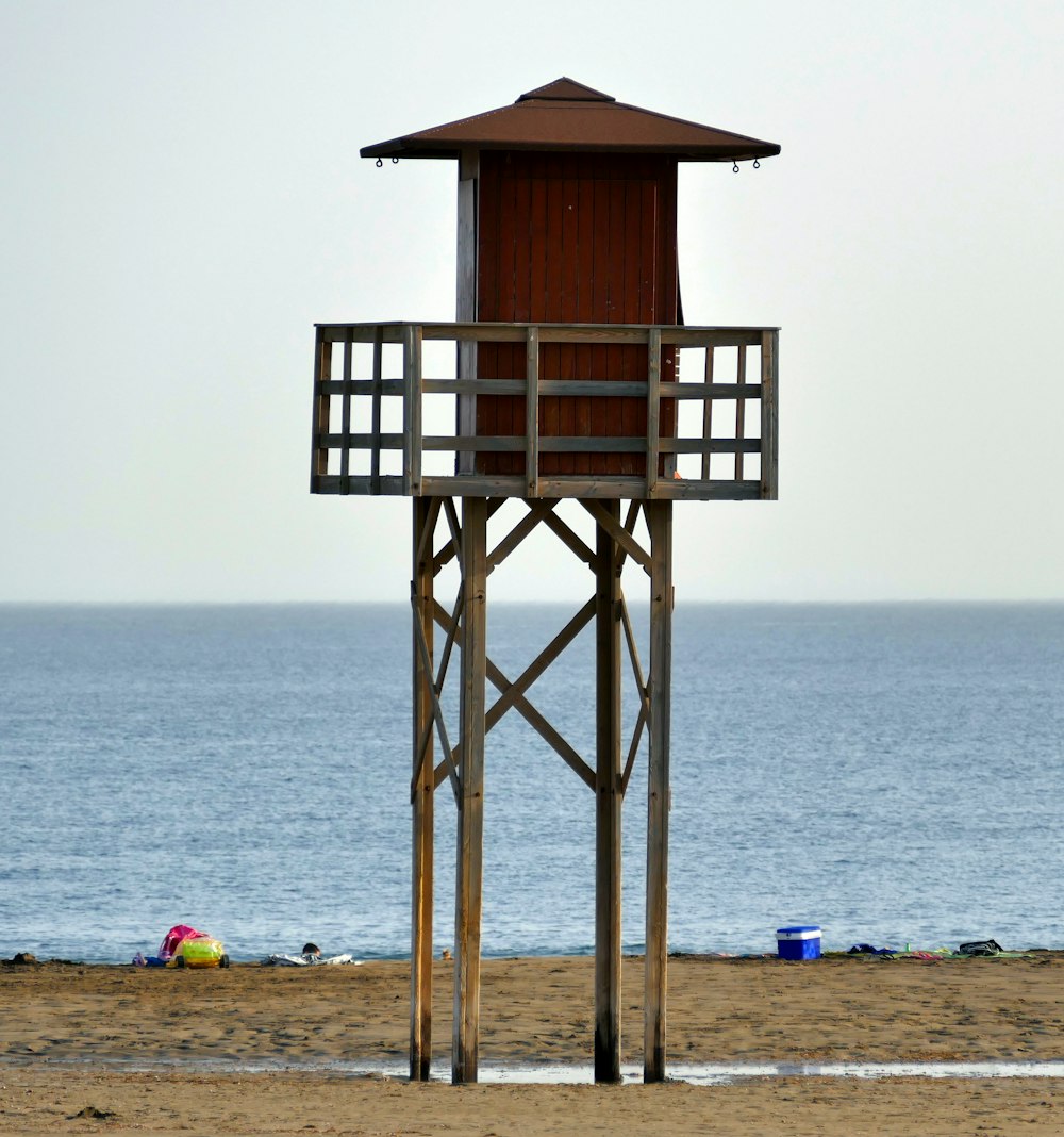 Torre de salvavidas de madera marrón en la playa durante el día