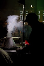 A candid moment of a street vendor in Singapore, framed by muted urban tones and gentle contrasts.