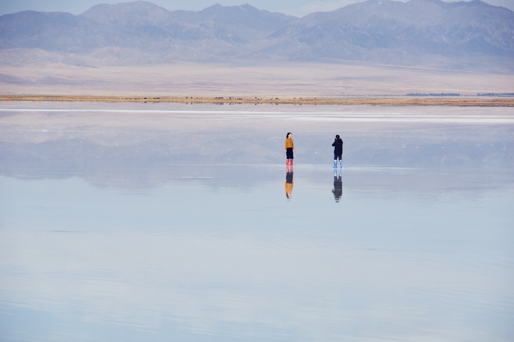 person in black jacket and black pants walking on brown field during daytime