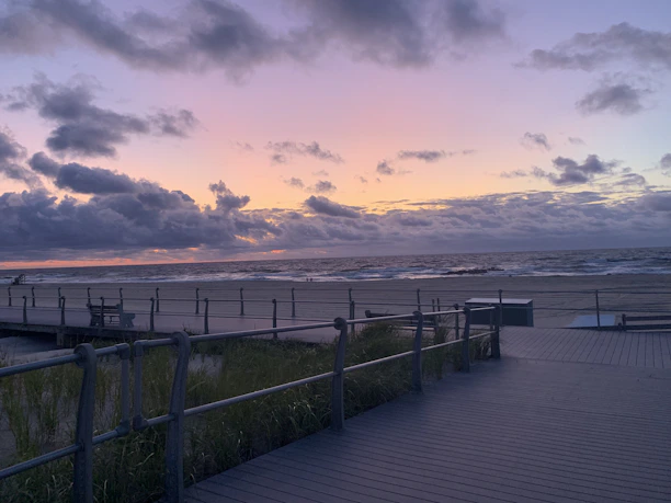 A moody nighttime shot of Atlantic City's iconic boardwalk illuminated under stormy skies.