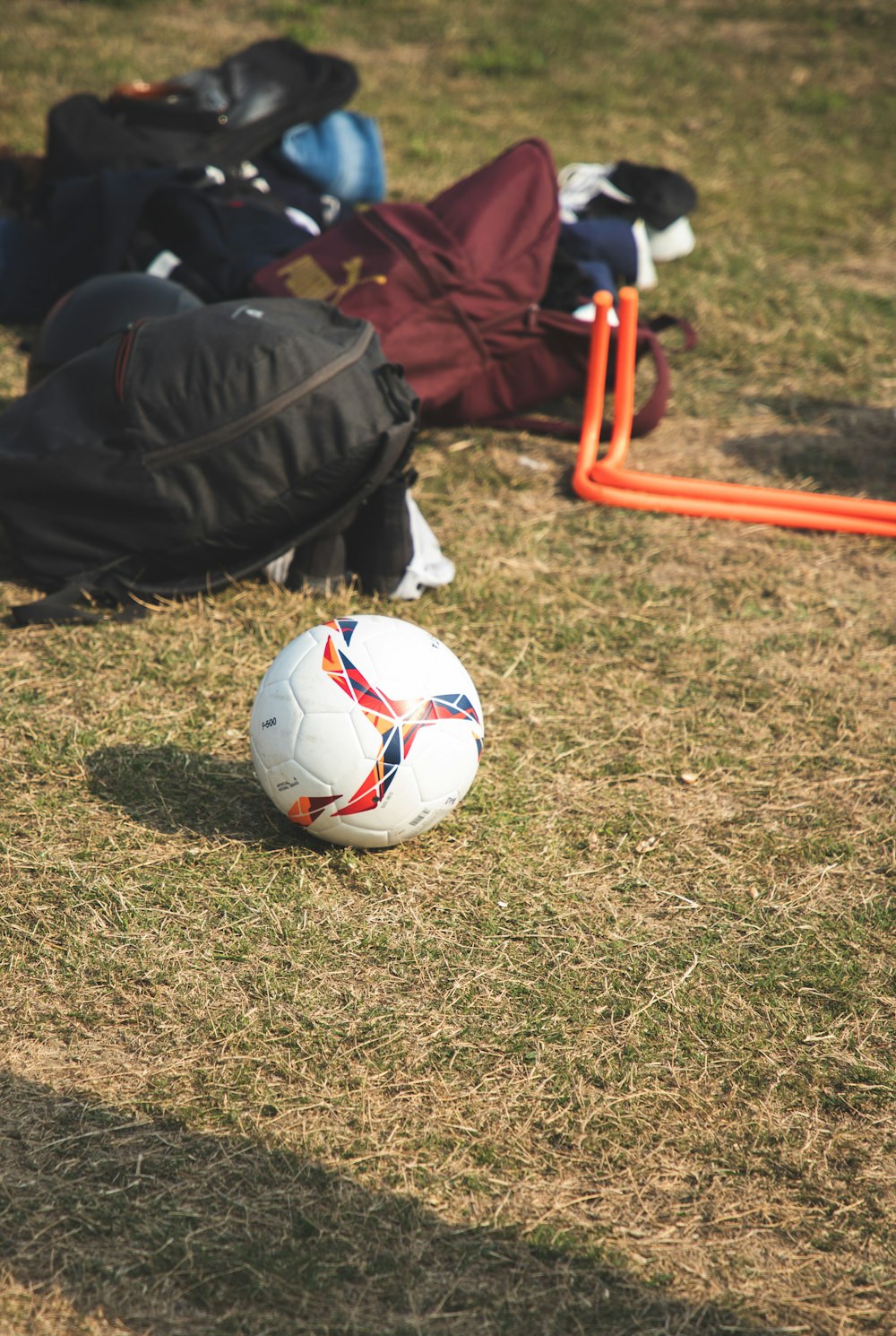 white and red soccer ball on green grass field