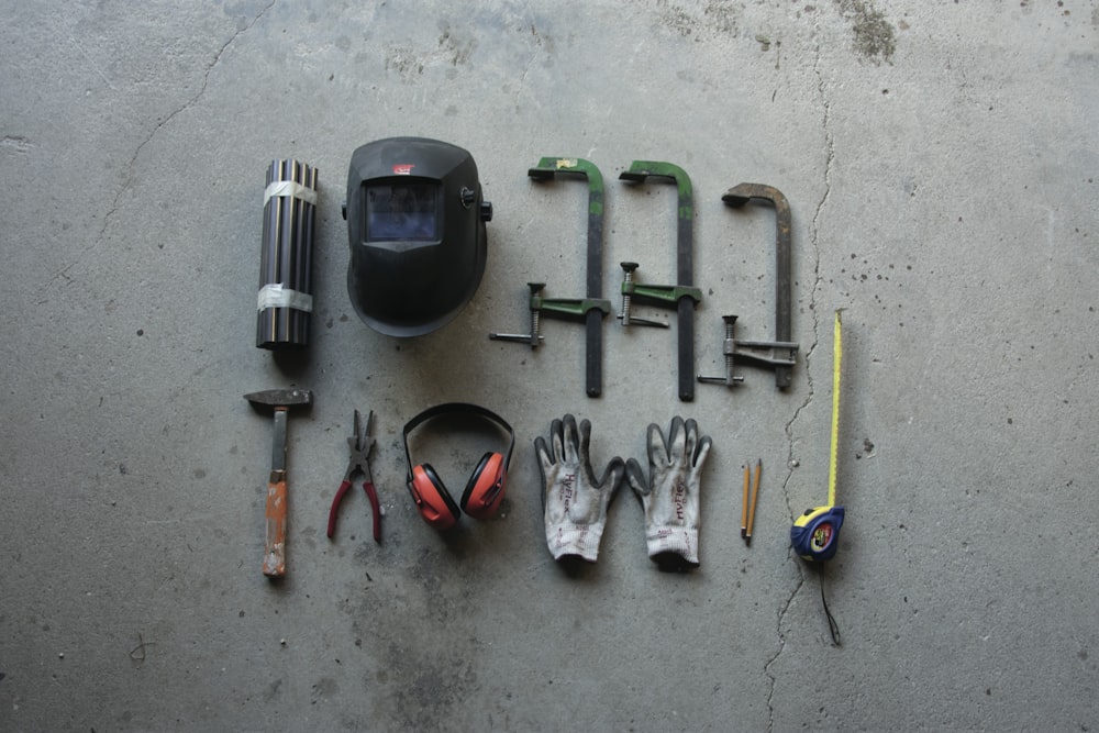 assorted hand tools on gray concrete floor
