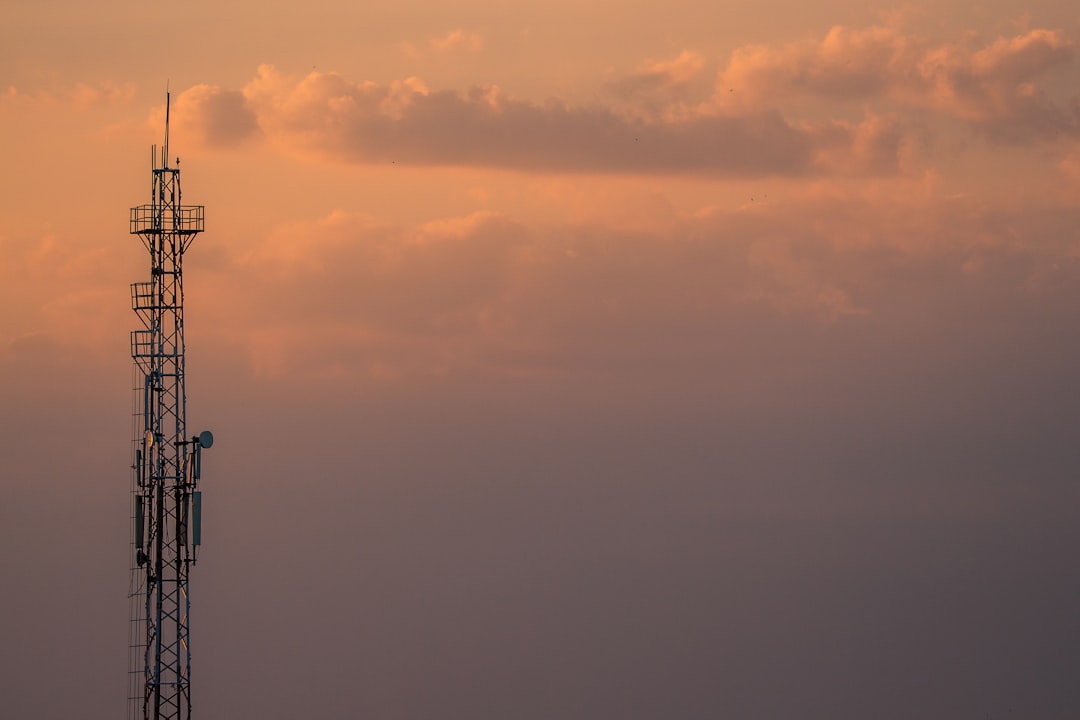 silhouette of tower under cloudy sky during sunset