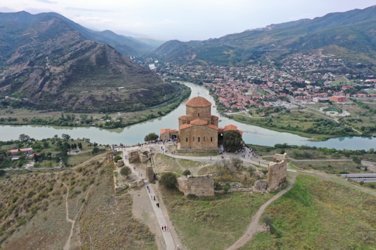 aerial view of brown concrete building near body of water during daytime in Tbilisi National Park Georgia