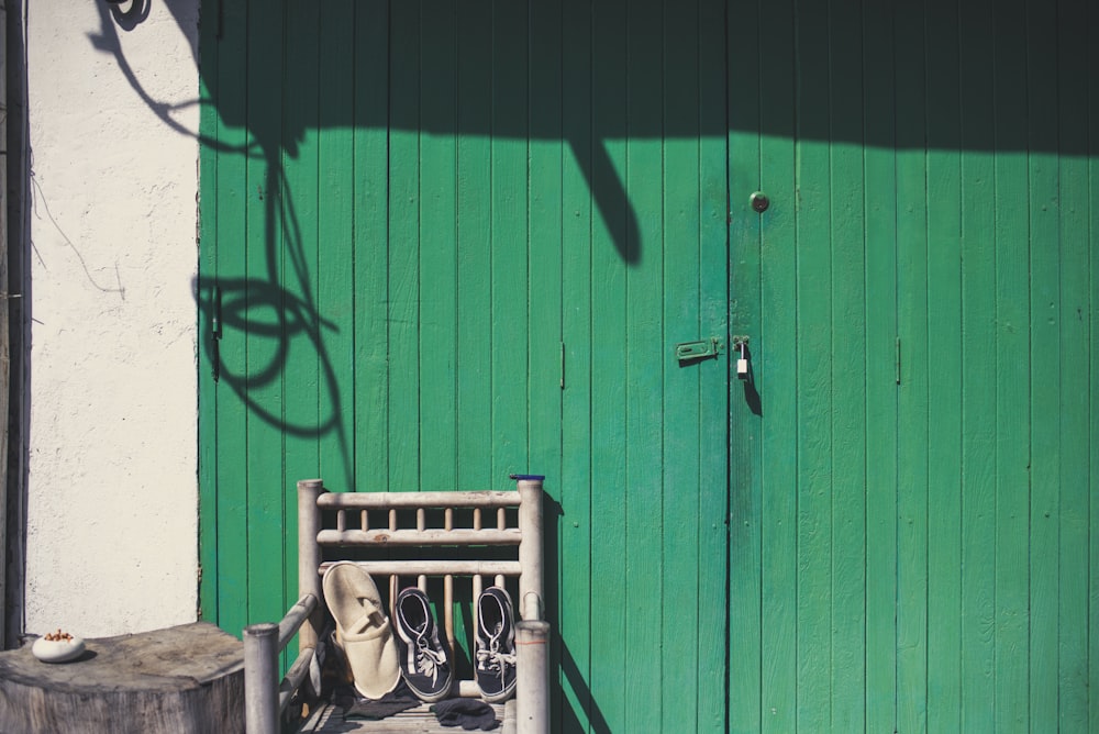 green metal bench beside green wall