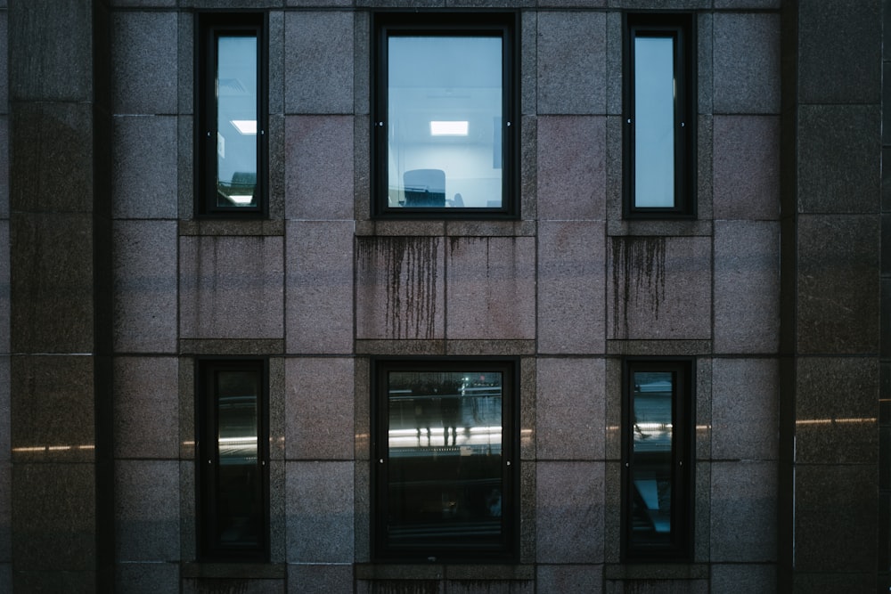 schwarz gerahmtes Glasfenster an brauner Ziegelwand