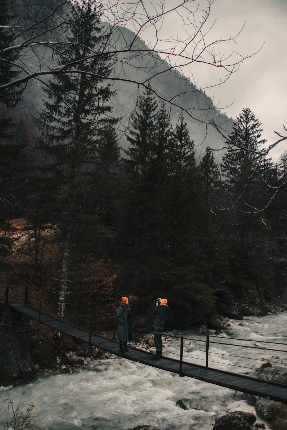 man in black jacket standing on bridge during daytime