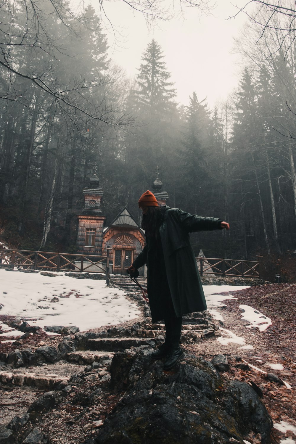 person in black coat standing on snow covered ground during daytime