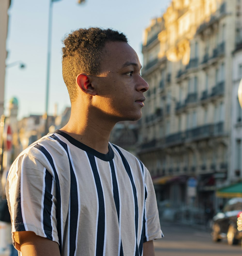 man in white and black crew neck t-shirt standing on street during daytime