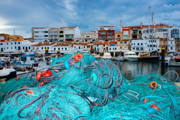 Fishing nets on the quay in front of the harbour — Menorca, Spain