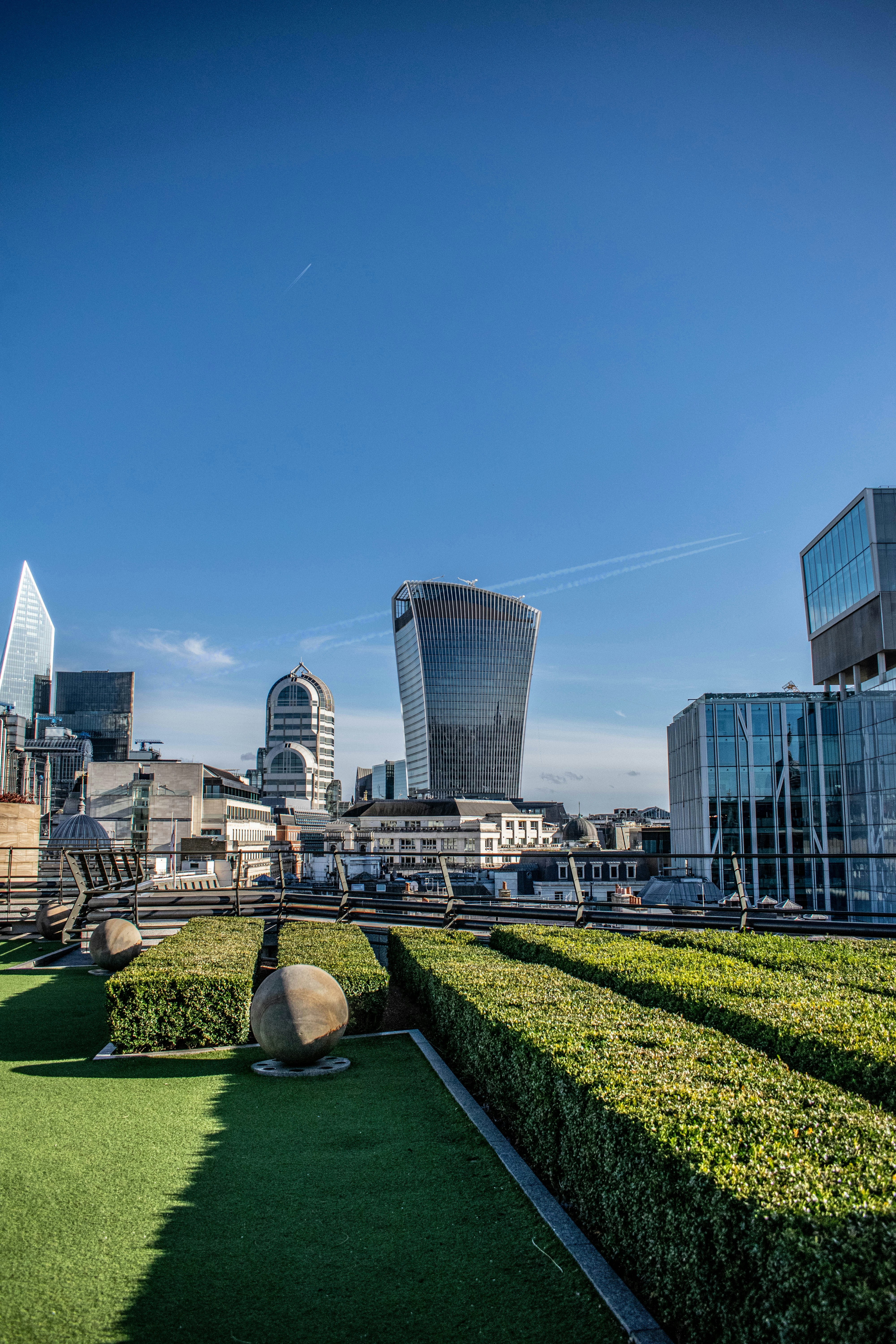 green grass field near city buildings during daytime