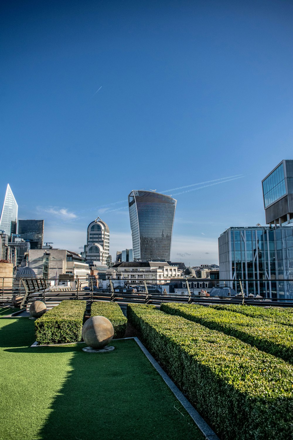 Campo de césped verde cerca de los edificios de la ciudad durante el día