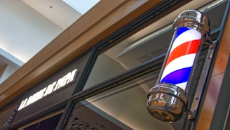 Exterior view of the Oborniki barber shop with a classic barber pole.