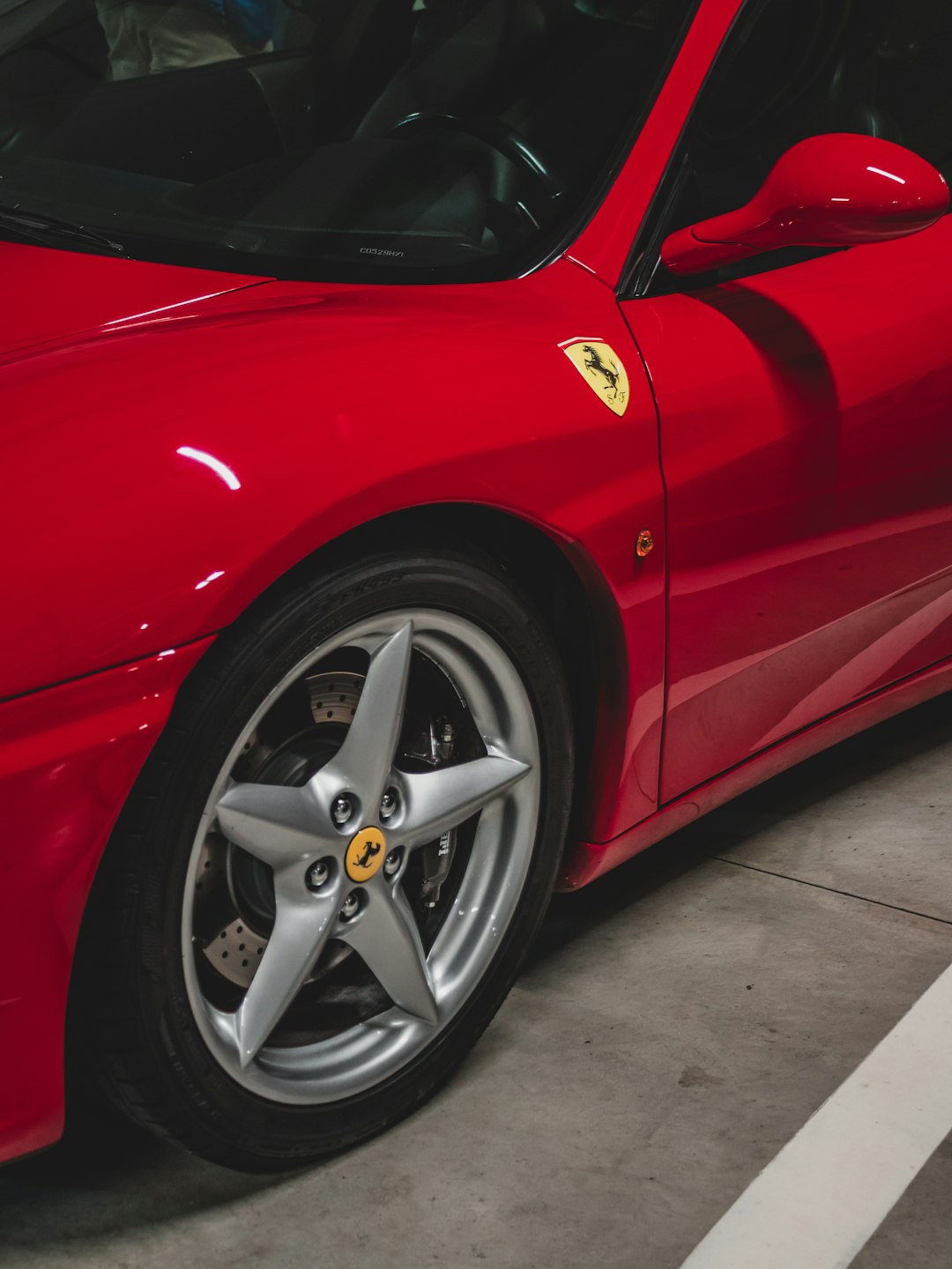 red ferrari car on gray pavement