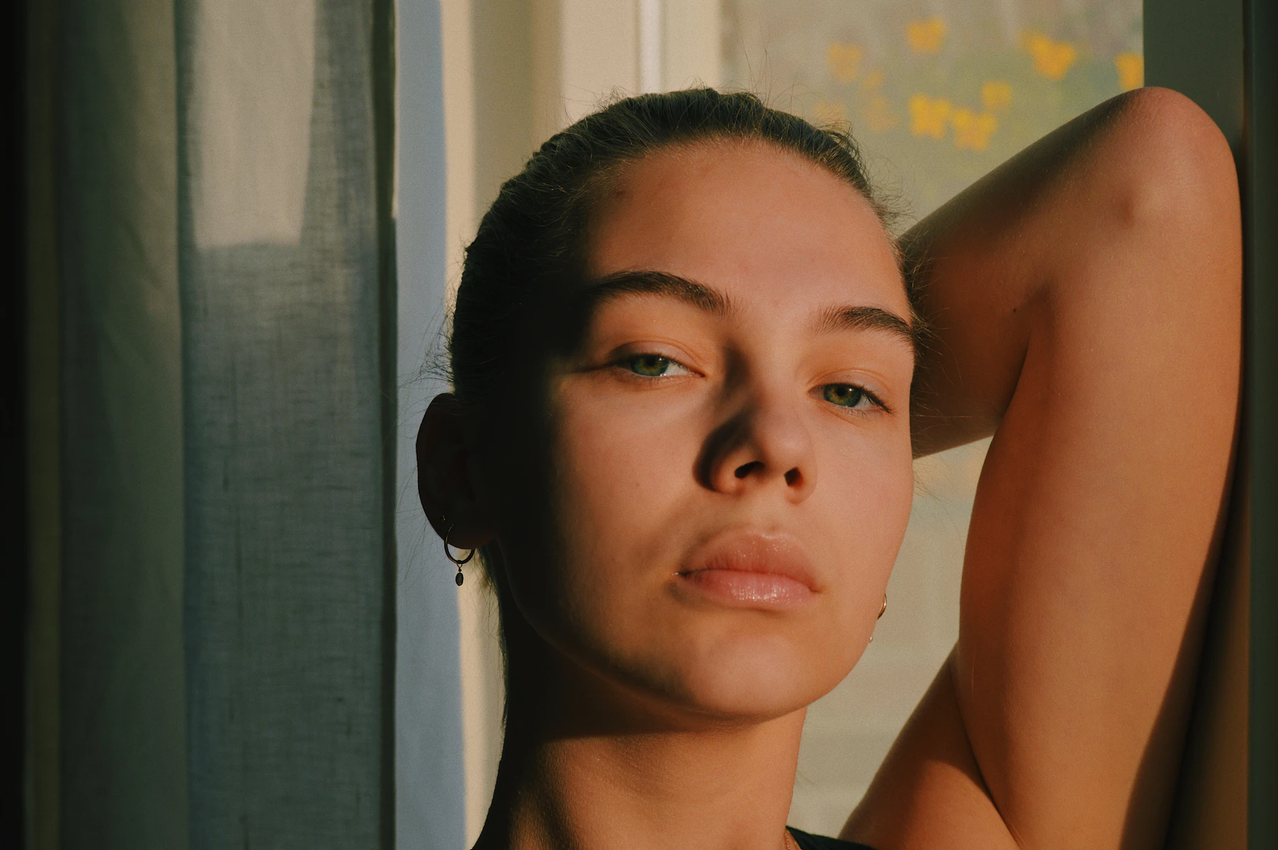 A woman by a window in soft, warm light