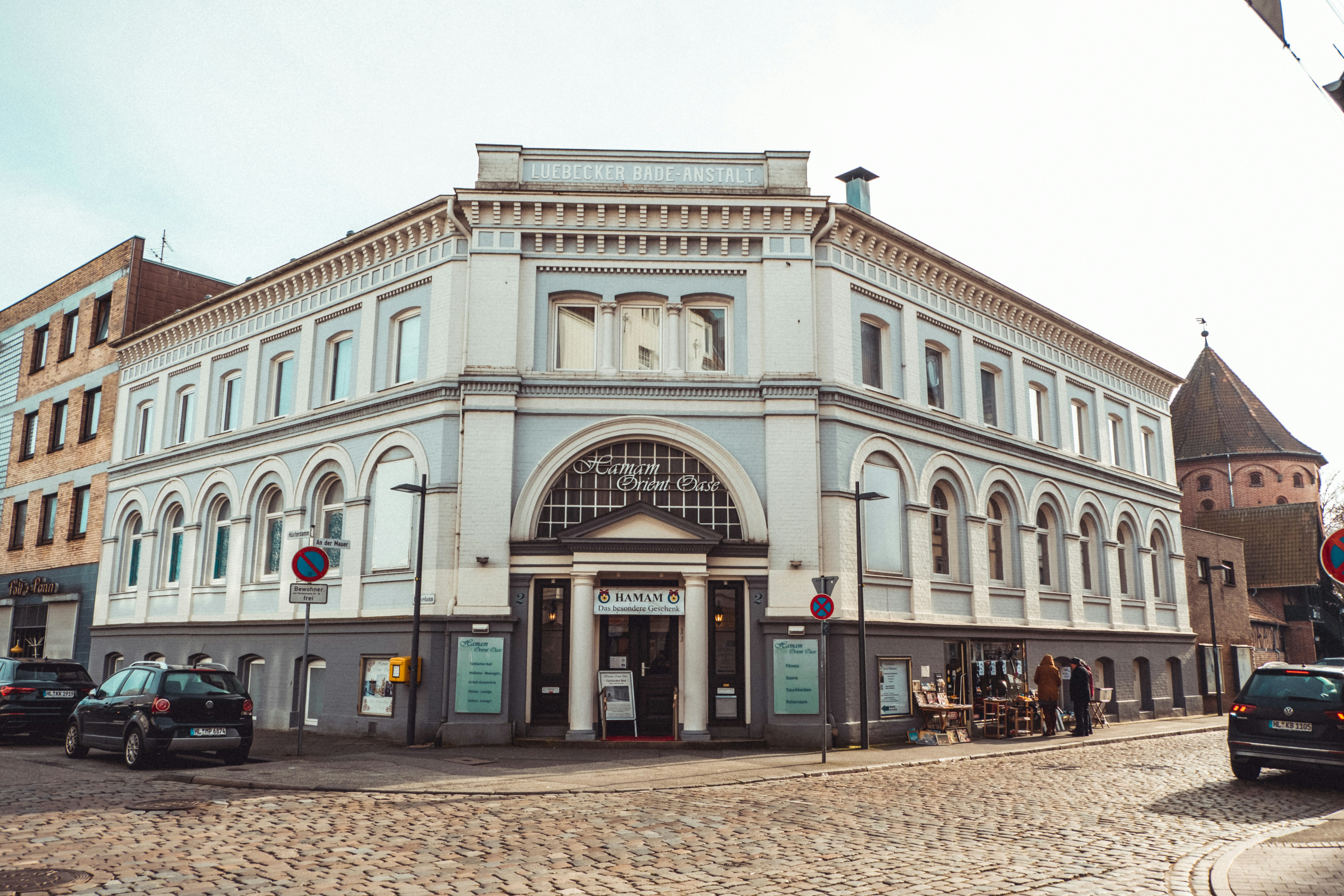 Menschen, die tagsüber in der Nähe des braunen Betongebäudes spazieren gehen