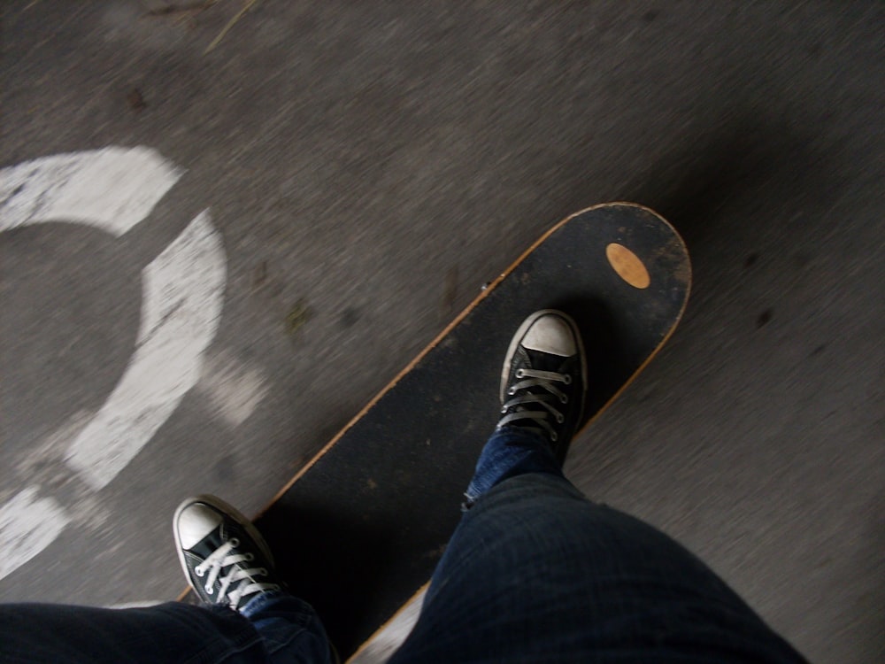 person in blue denim jeans and black and white sneakers