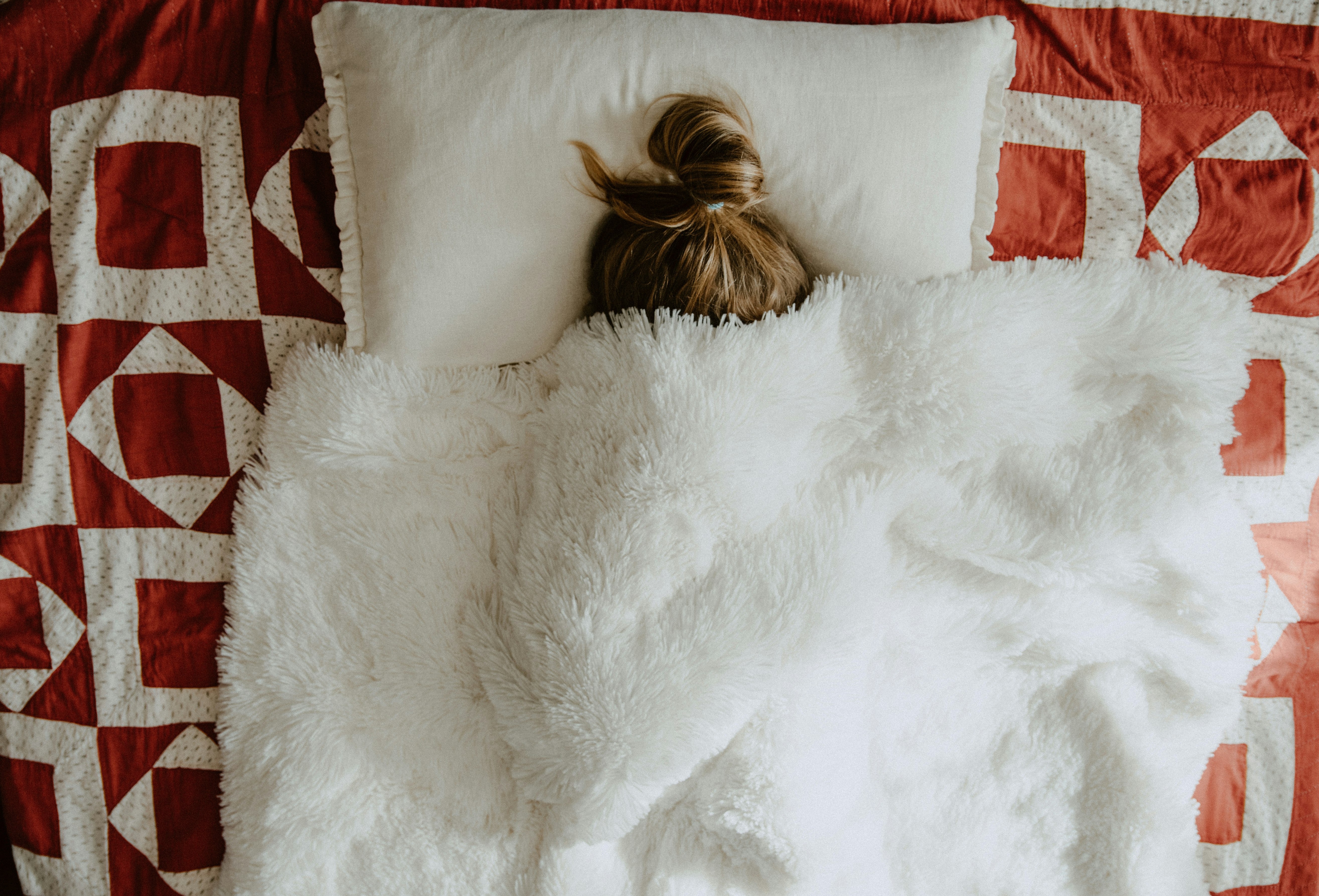 white fur textile on red and white textile