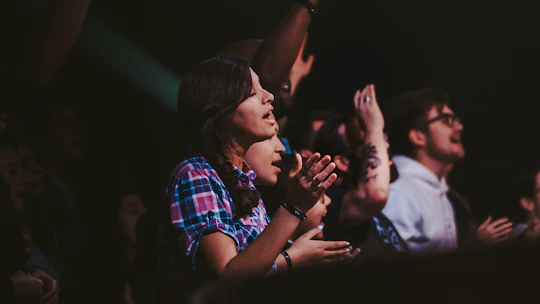Close-up of hands clapping along to familiar tunes during a lively senior music session.