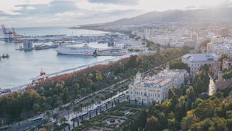white and blue boat on body of water near city buildings during daytime