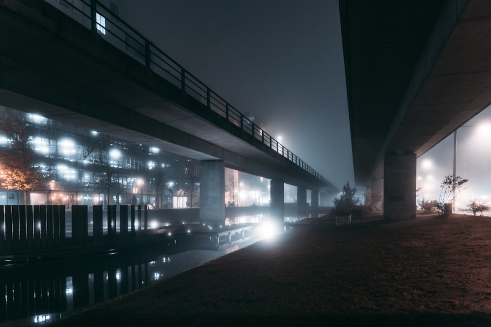 夜間に橋の近くの歩道を歩く人々