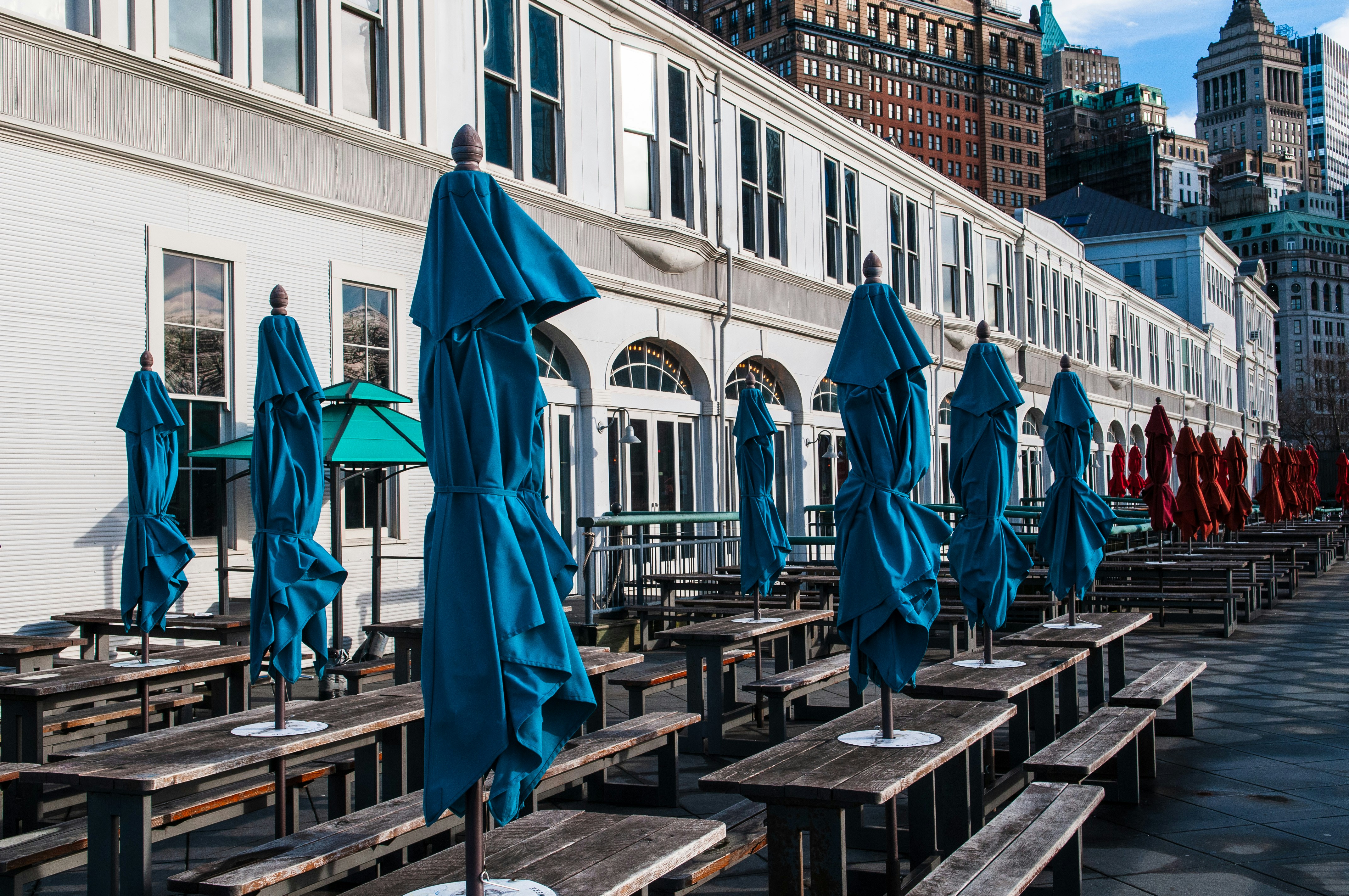 茶色の木製のベンチに青い傘