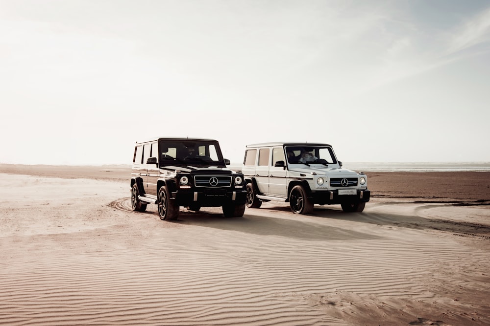 white and black jeep wrangler on brown sand during daytime