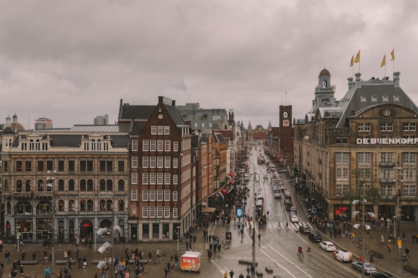people walking on street near buildings during daytime in Amsterdam Dam Square