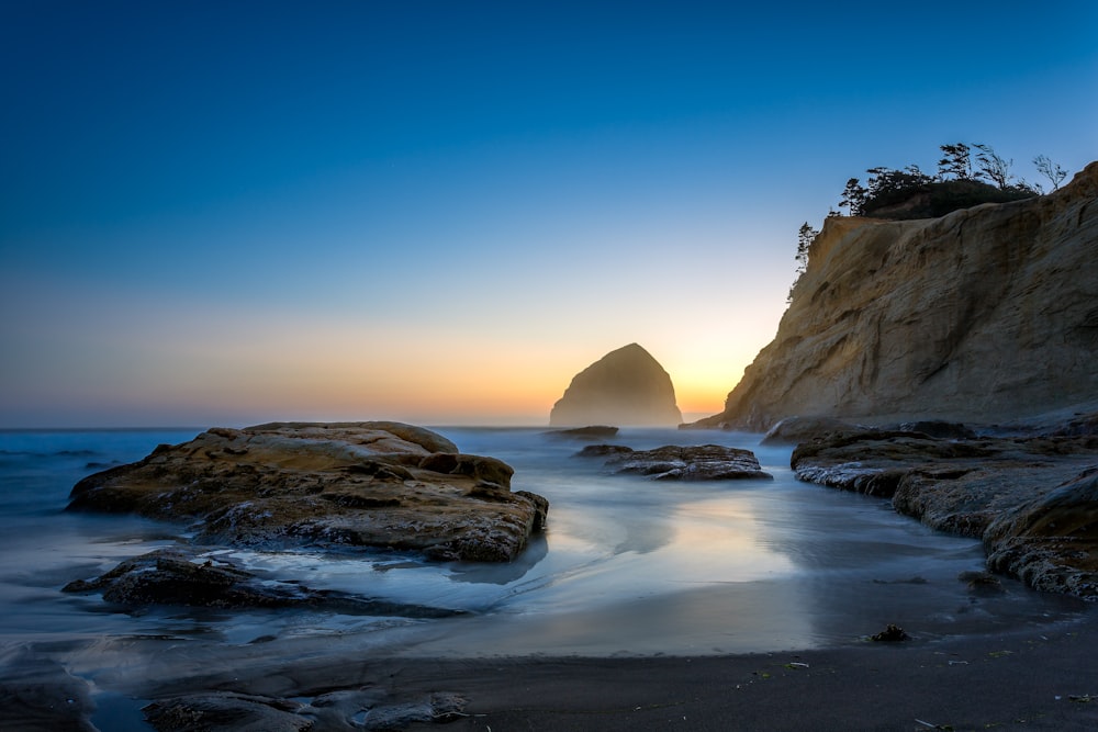 brown rock formation on sea during daytime