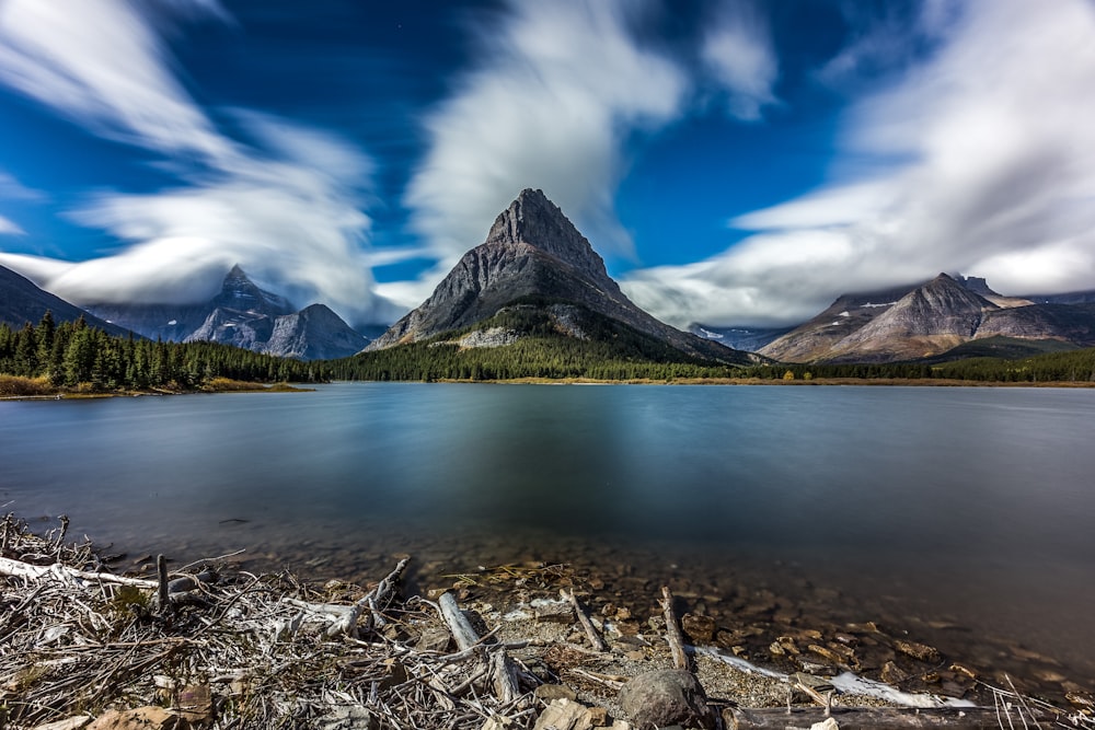 lake near mountain under blue sky during daytime