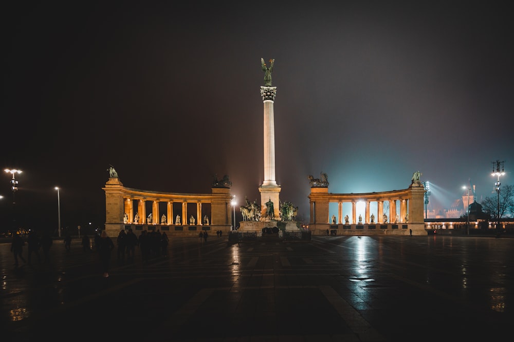 a night view of a building with a monument in the background