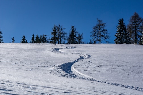 A serene mountain slope with fresh snow tracks showing a perfect day for skiing.
