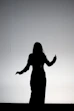 silhouette of woman raising her hands