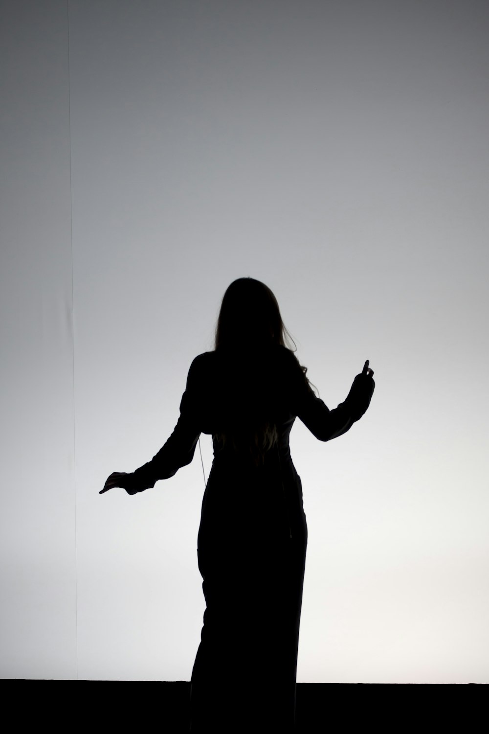 silhouette of woman raising her hands