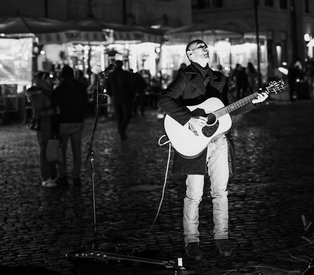 man in black jacket playing guitar