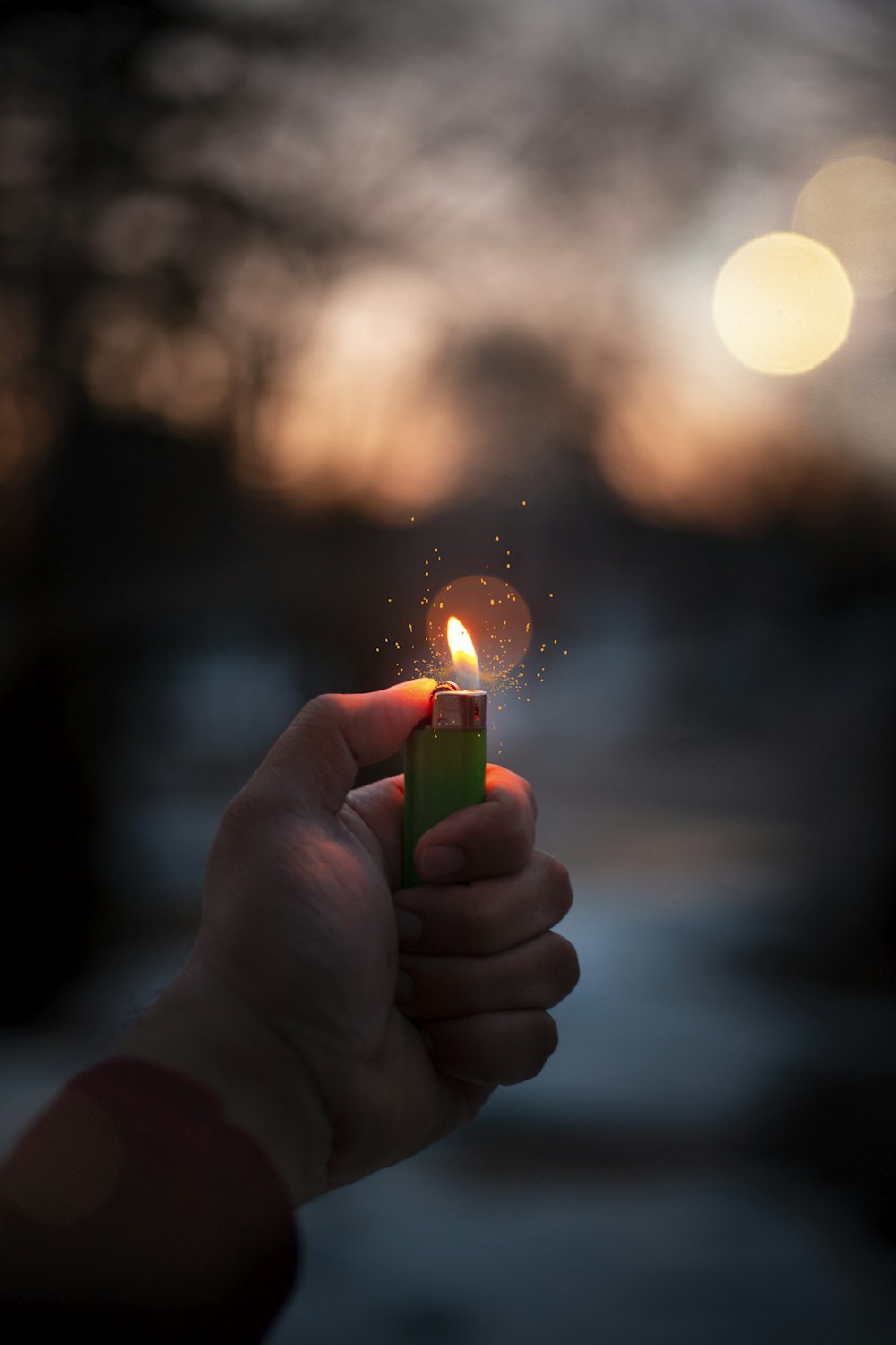 person holding lighted disposable lighter