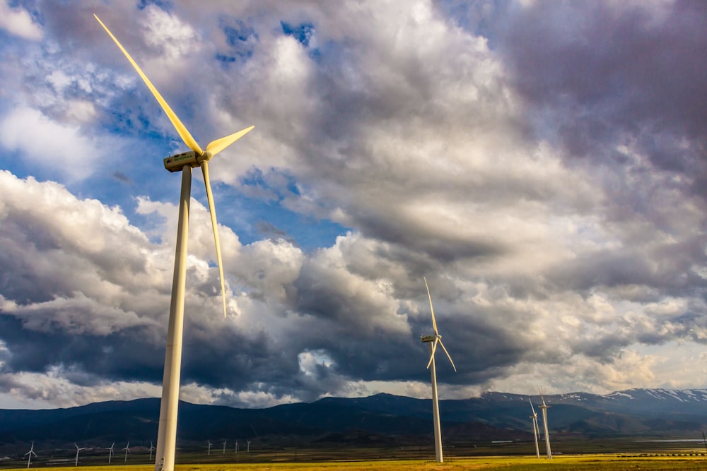 white wind turbine under blue sky and white clouds during daytime