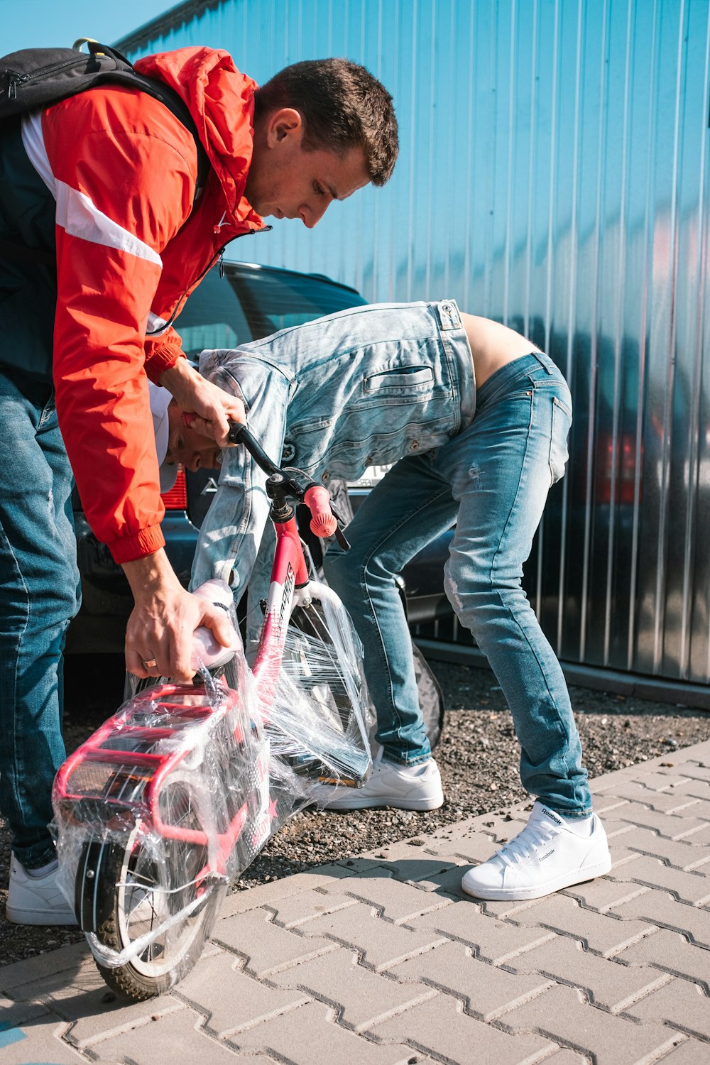 man in blue denim jacket holding clear plastic bag