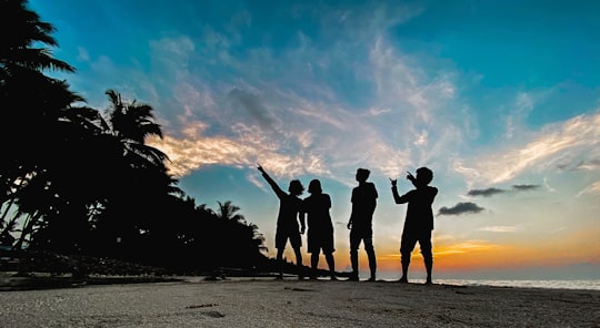 silhouette of people standing on beach during sunset in Mathiveri Maldives