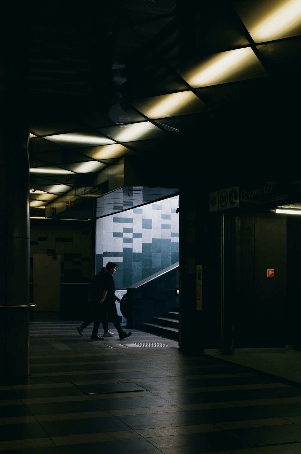 man in black jacket walking on hallway