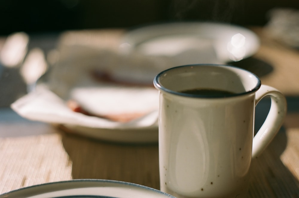 white ceramic mug on brown wooden table