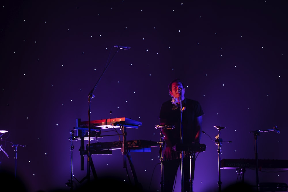 man in black suit singing on stage