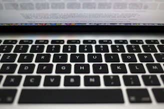 Close-up of hands typing letters into a sleek digital word unscrambler interface on a modern laptop.