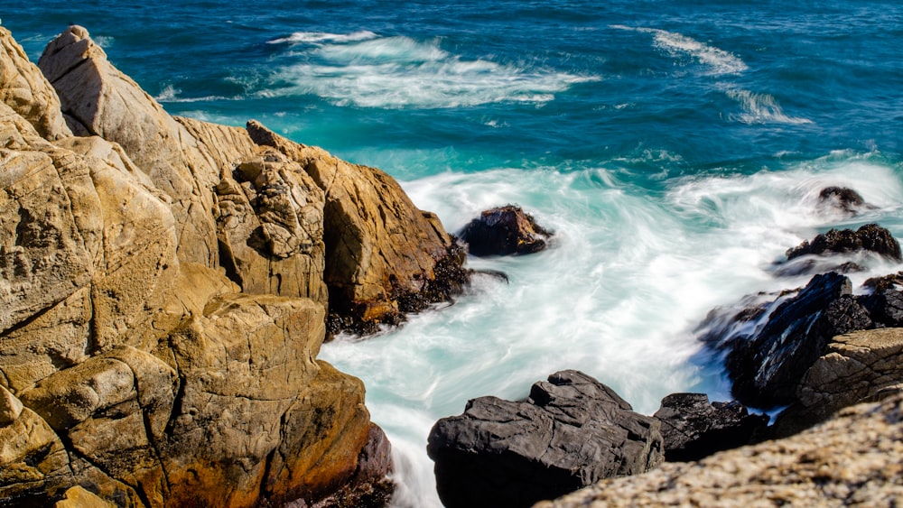 brown rock formation beside blue sea during daytime